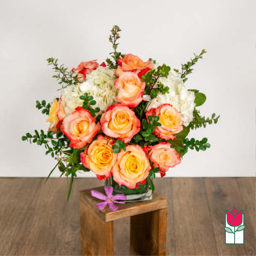 Bouquet of peach and pink roses with white hydrangeas in a glass vase