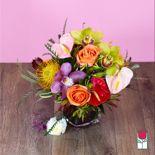 Mixed bouquet in a glass vase with roses, orchids, and anthuriums