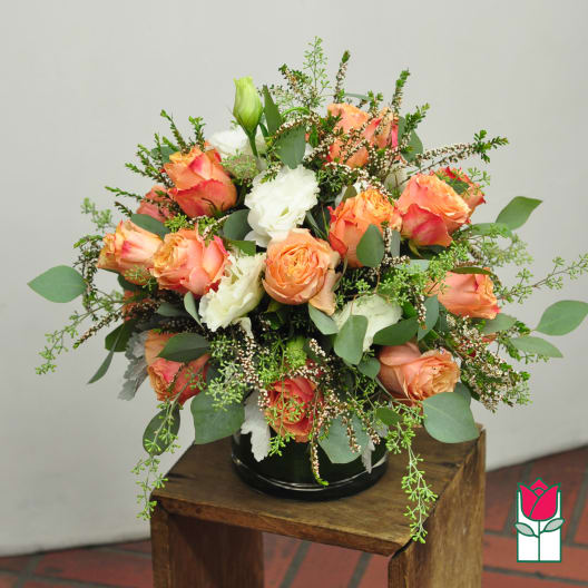 Peach and white rose bouquet in a black vase
