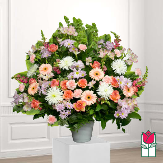 Large mixed bouquet in a gray vase with pink, peach, and white flowers