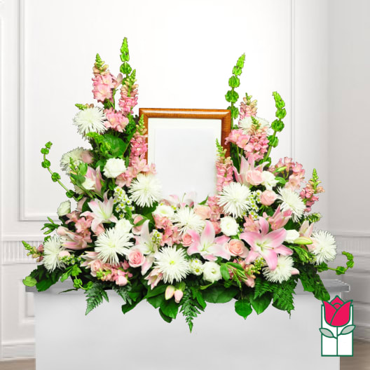Pink and white floral funeral wreath with a wooden frame center