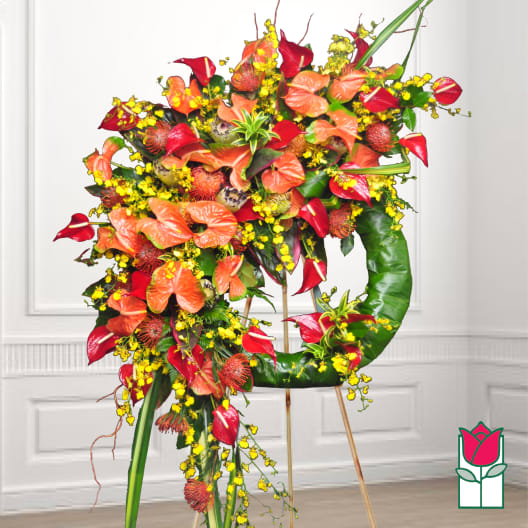 Large tropical floral wreath on an easel with red and orange blooms