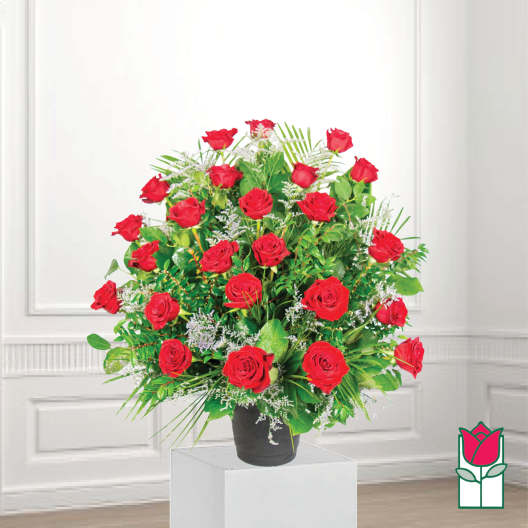 Red roses arranged in a black vase with greenery