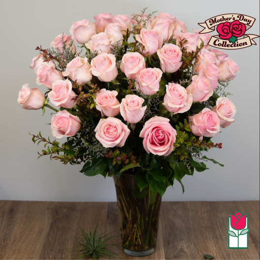 Pink roses arranged in a tall glass vase