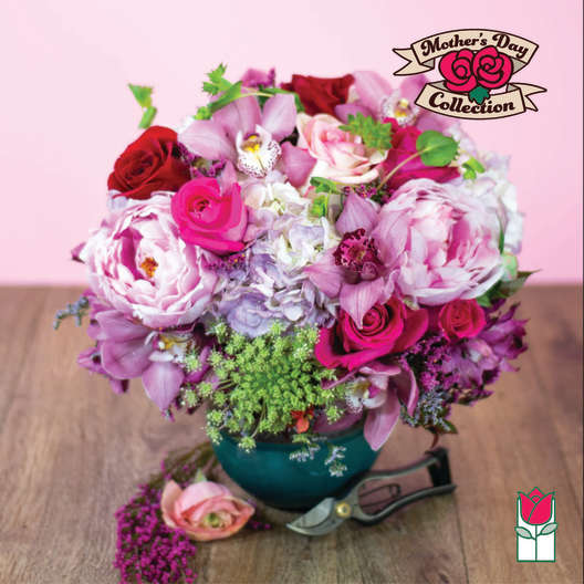 Pink and red mixed flower arrangement in a teal vase
