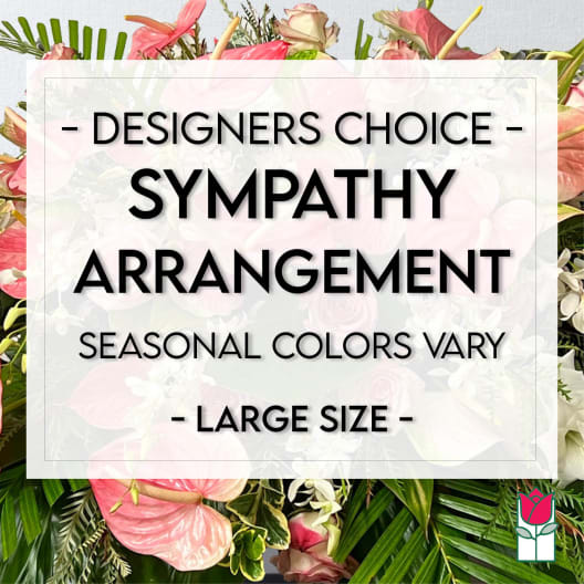 Large sympathy arrangement with pink flowers and tropical foliage