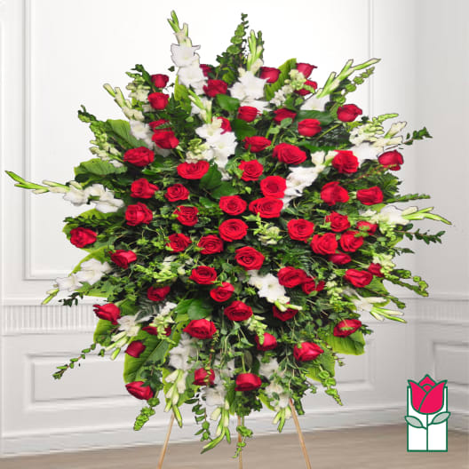Large standing spray of red roses and white flowers on an easel