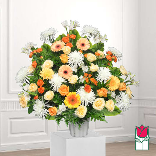 Mixed bouquet of orange, peach, and white flowers in a white vase