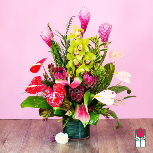 Tropical bouquet with pink ginger, orchids, and red anthuriums in a vase