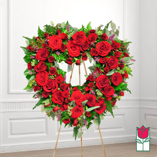 Heart-shaped wreath of red roses on a stand