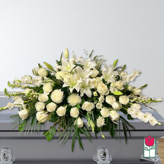 White floral casket spray with lilies and roses