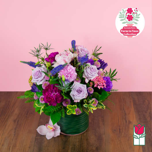 Lavender and pink flower arrangement in a green vase