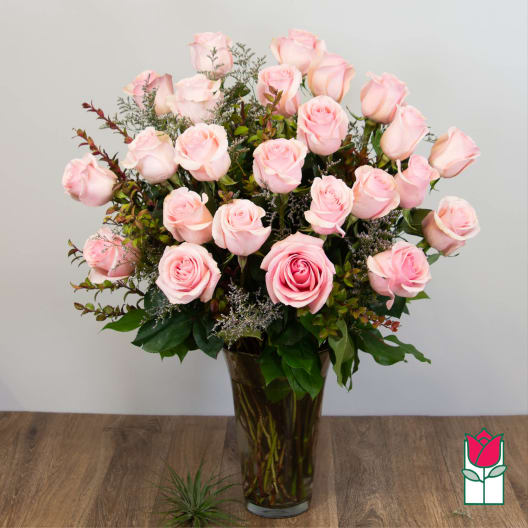 Pink roses arranged in a tall glass vase