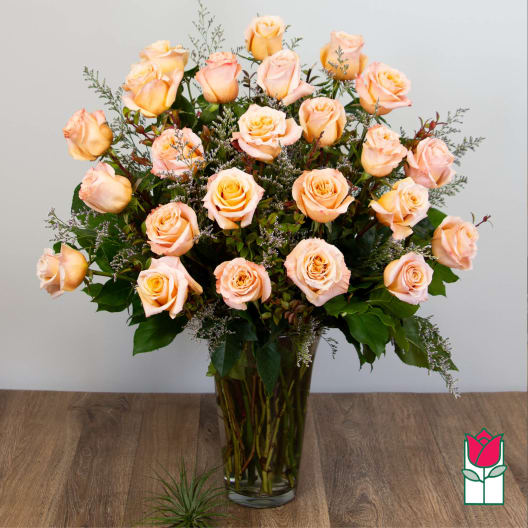 Peach roses arranged in a clear glass vase