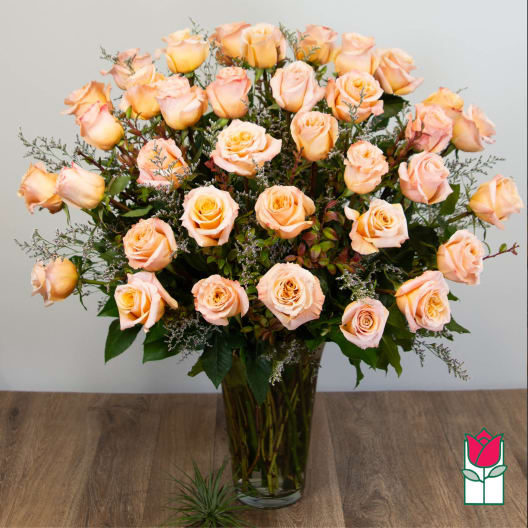 Peach roses arranged in a clear glass vase
