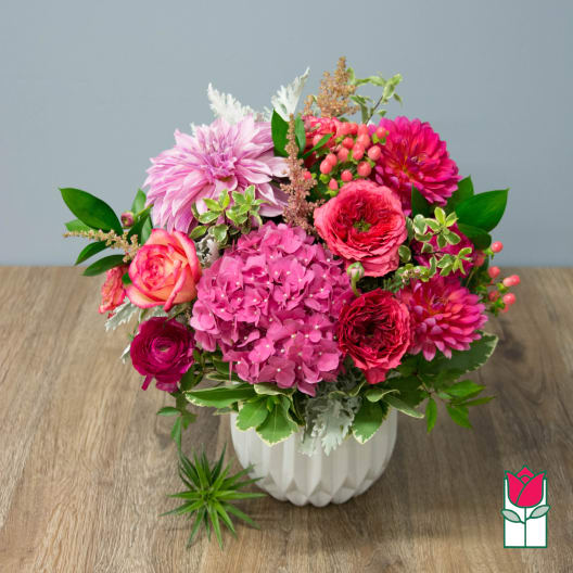 Pink and magenta mixed bouquet in a white vase