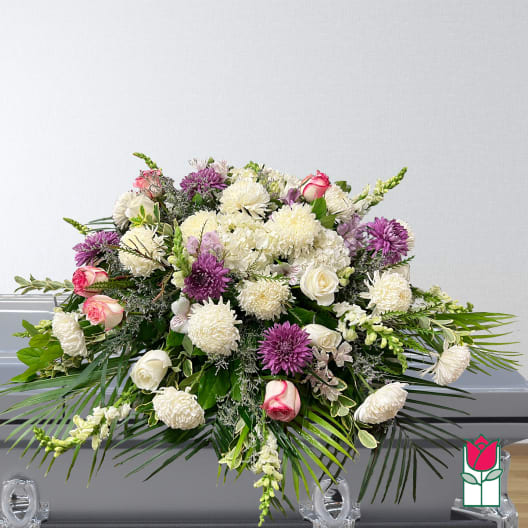 Large funeral spray with white and purple flowers and pink roses