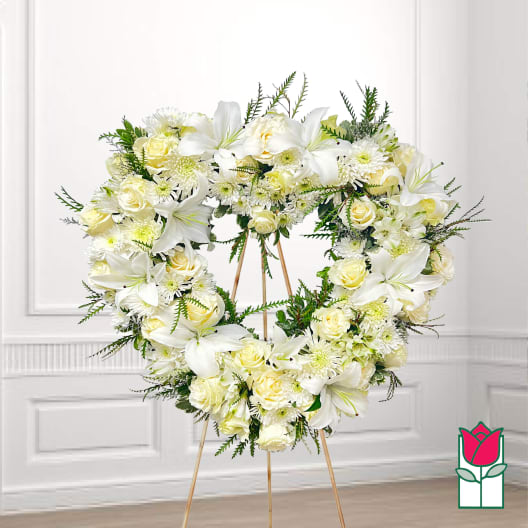 Heart-shaped white floral wreath on a stand