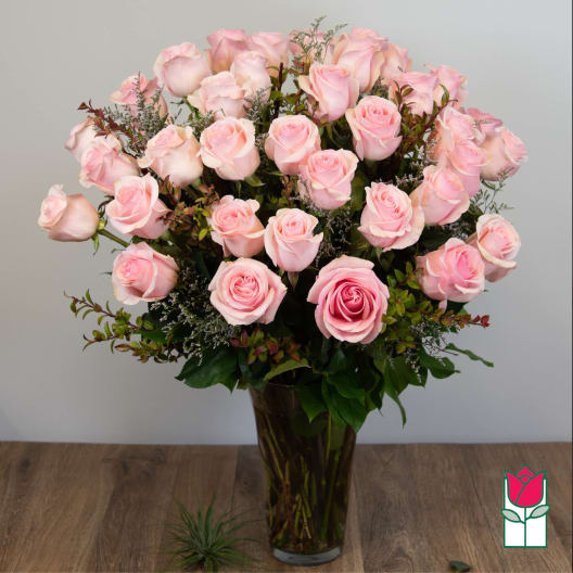 Bouquet of pale pink roses in a tall glass vase