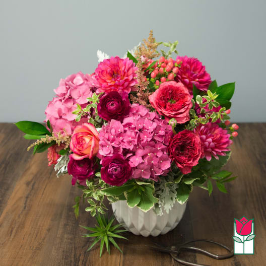Pink mixed flower arrangement in a white vase