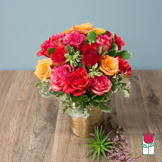 Bouquet of multicolored roses in a gold vase