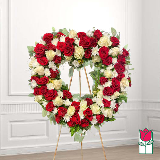 Heart-shaped wreath of red and white roses on a stand