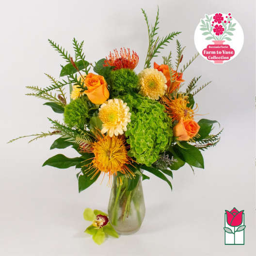 Orange roses and yellow blooms in a glass vase