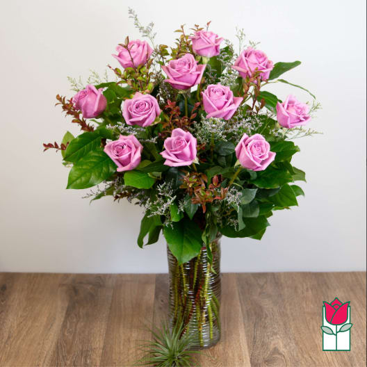 Pink roses arranged in a tall glass vase