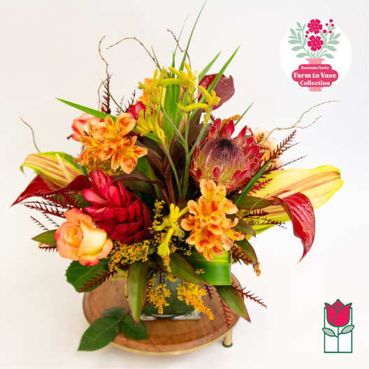 Tropical bouquet with orange and red flowers in a glass vase