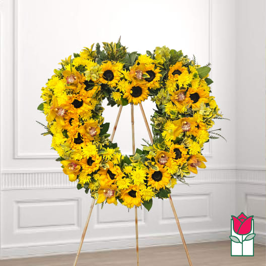 Heart-shaped yellow floral wreath on a standing easel