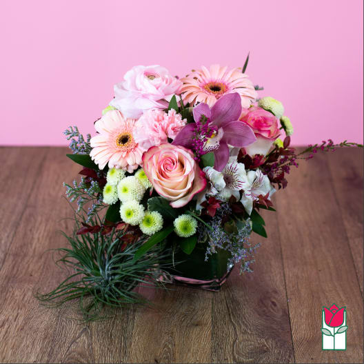 Pink and white mixed flower arrangement in a low square container
