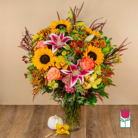 Mixed bouquet in a glass vase with sunflowers, lilies, and roses