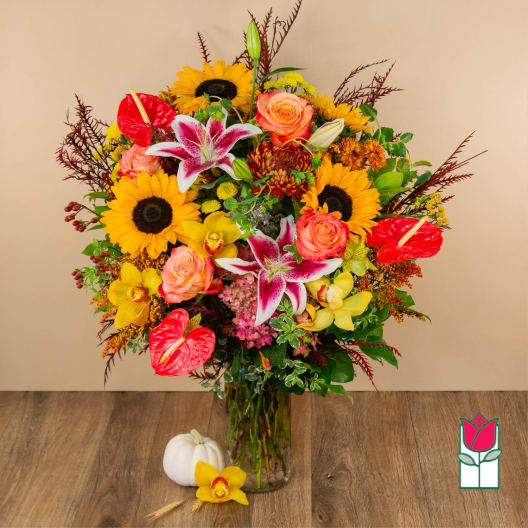 Mixed bouquet in a glass vase with sunflowers, roses, lilies, and anthuriums