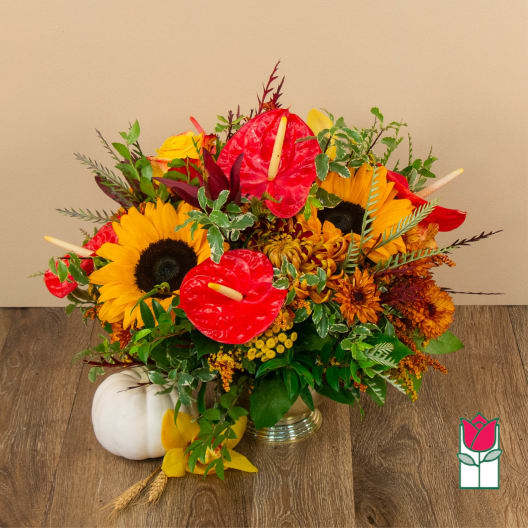 Bright mixed bouquet with sunflowers, red anthuriums, and autumn flowers in a vase
