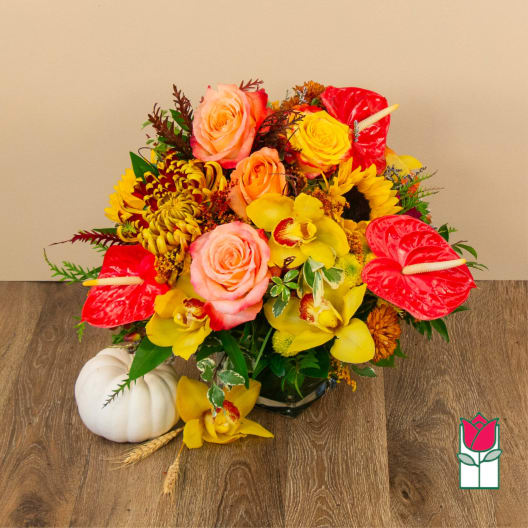 Bright mixed bouquet with roses, orchids, sunflowers, and red anthuriums in a vase