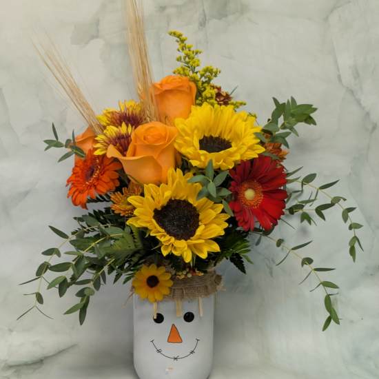 Sunflower and rose arrangement in a snowman vase