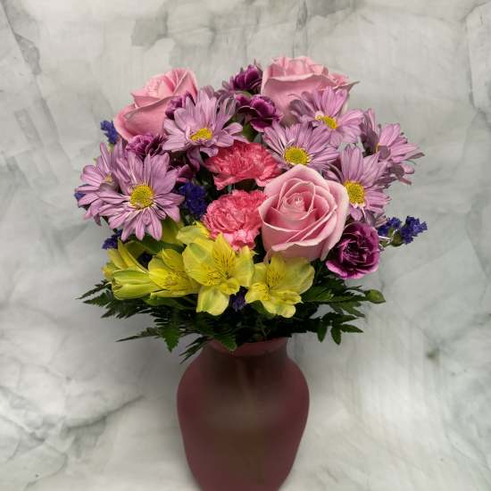 Pink and purple mixed bouquet in a burgundy vase