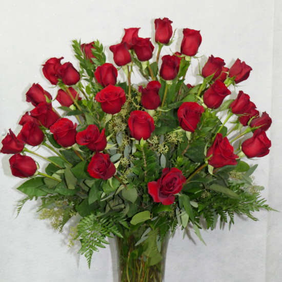 Red roses arranged in a clear glass vase