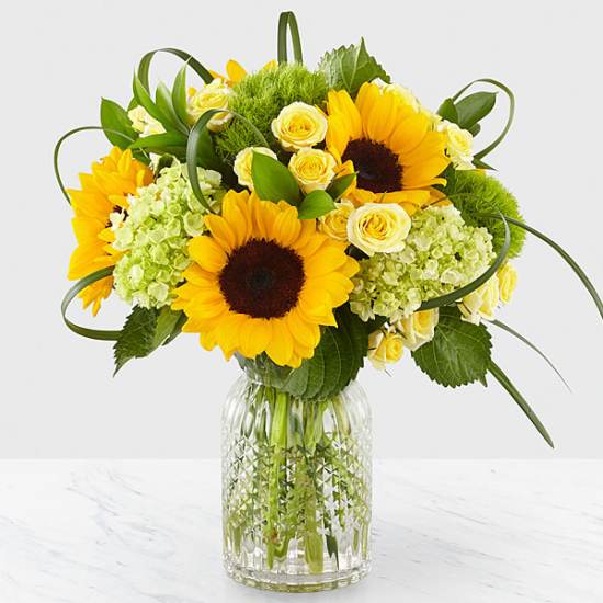 Sunflower and rose bouquet in a clear glass vase