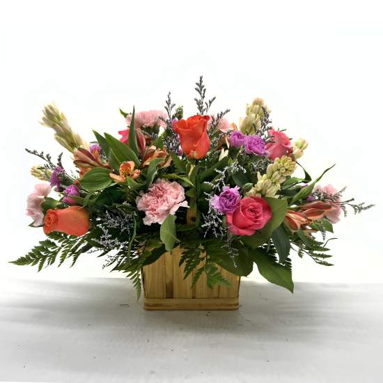 Mixed bouquet in a wooden basket with pink, orange, and purple flowers
