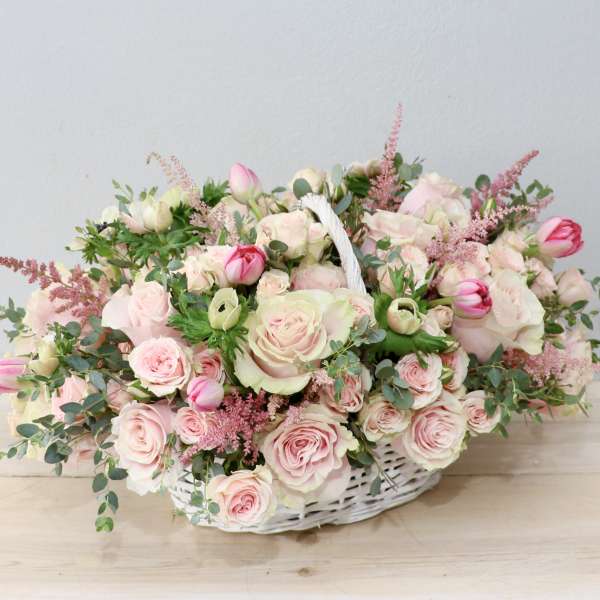 Pink and white rose bouquet in a white wicker basket