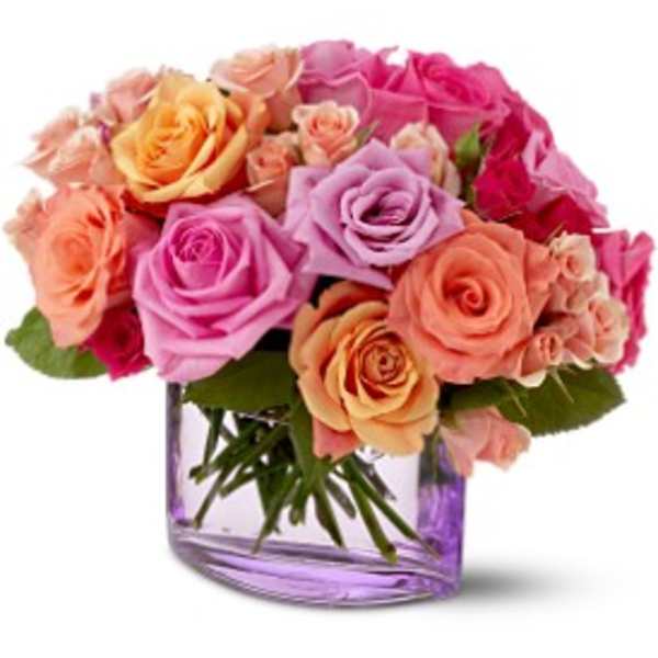 Bouquet of pink, peach, and lavender roses in a purple glass vase