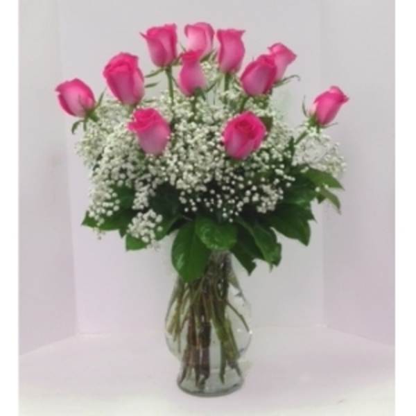 Pink roses arranged in a clear glass vase with white baby's breath
