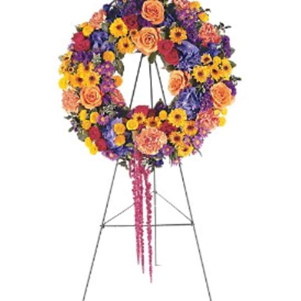 Bright multicolor standing wreath of roses and daisies on a metal easel