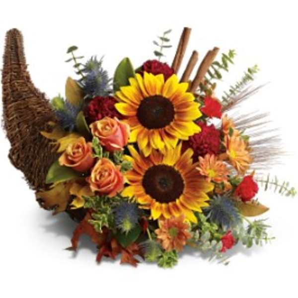 Autumn cornucopia arrangement with yellow sunflowers, orange roses, and red blooms in a wicker horn basket