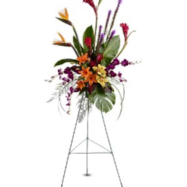 Tall tropical floral standing spray with orange lilies and purple orchids on a metal easel.