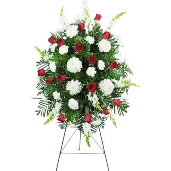 Standing funeral spray of red roses and white carnations on an easel