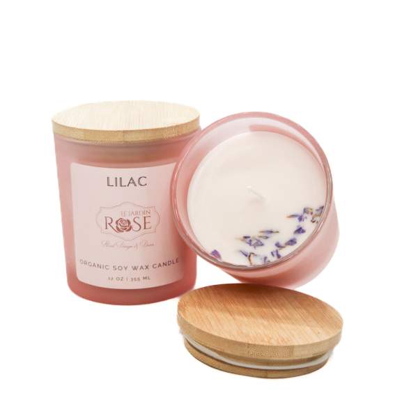 Pink lilac-scented candle in a glass jar with a wooden lid