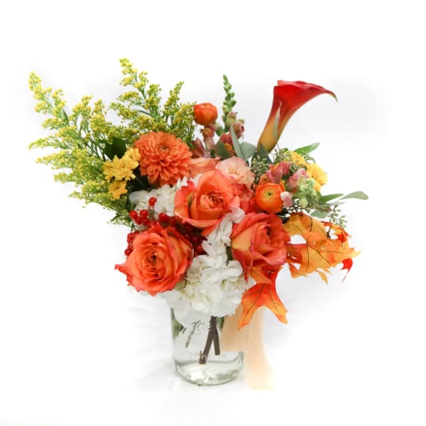 Orange and white mixed bouquet in a clear glass vase