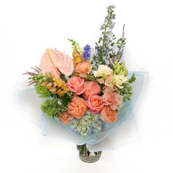 Pastel bouquet with roses, hydrangea, and anthurium in a glass vase
